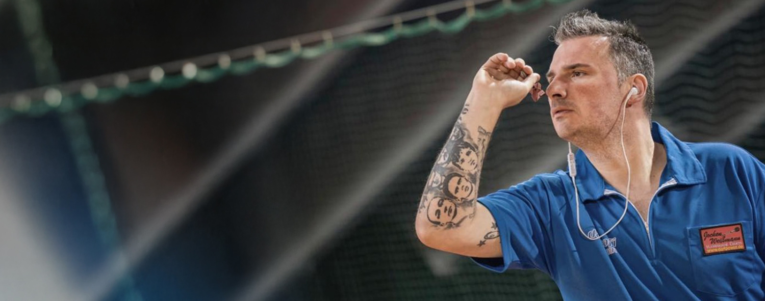 Dartespieler in blauem Poloshirt