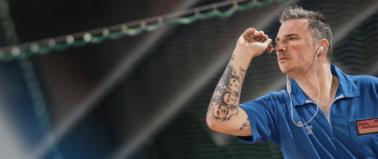 Dartespieler in blauem Poloshirt